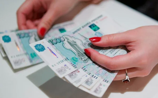 Руки тримають пачки російських рублів у ставці на відставку Путіна