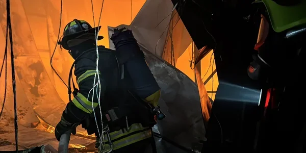 Рятувальник у палаючій будівлі на тлі російських атак на Україну