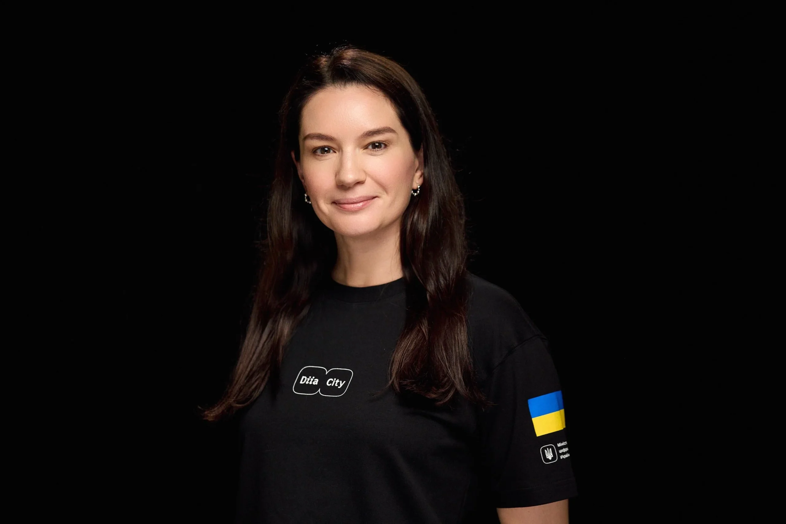 Жінка в футболці Play City з прапором України на рукаві