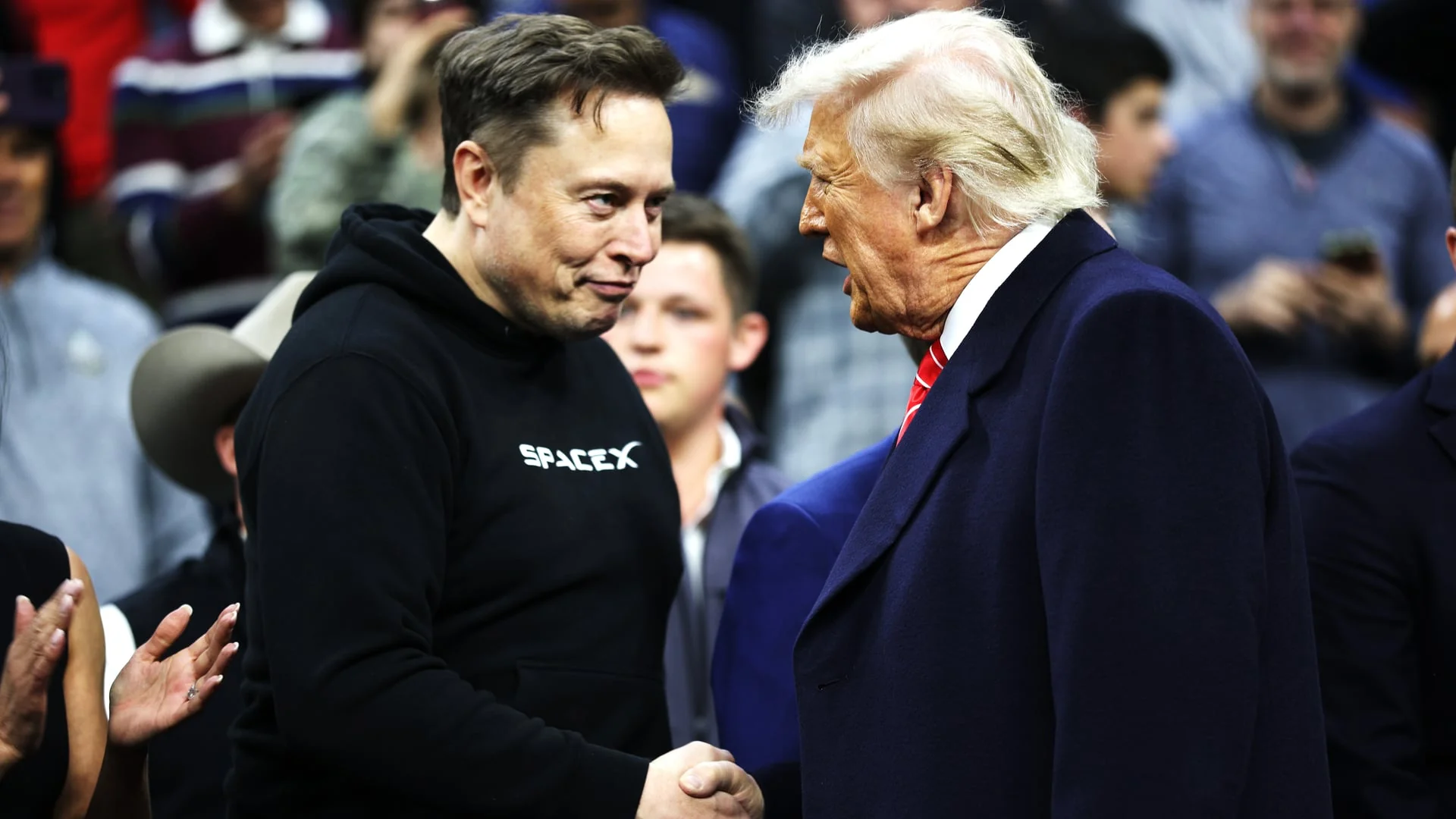 Дональд Трамп та Ілон Маск потискають руки під час зустрічі щодо плану ШІ